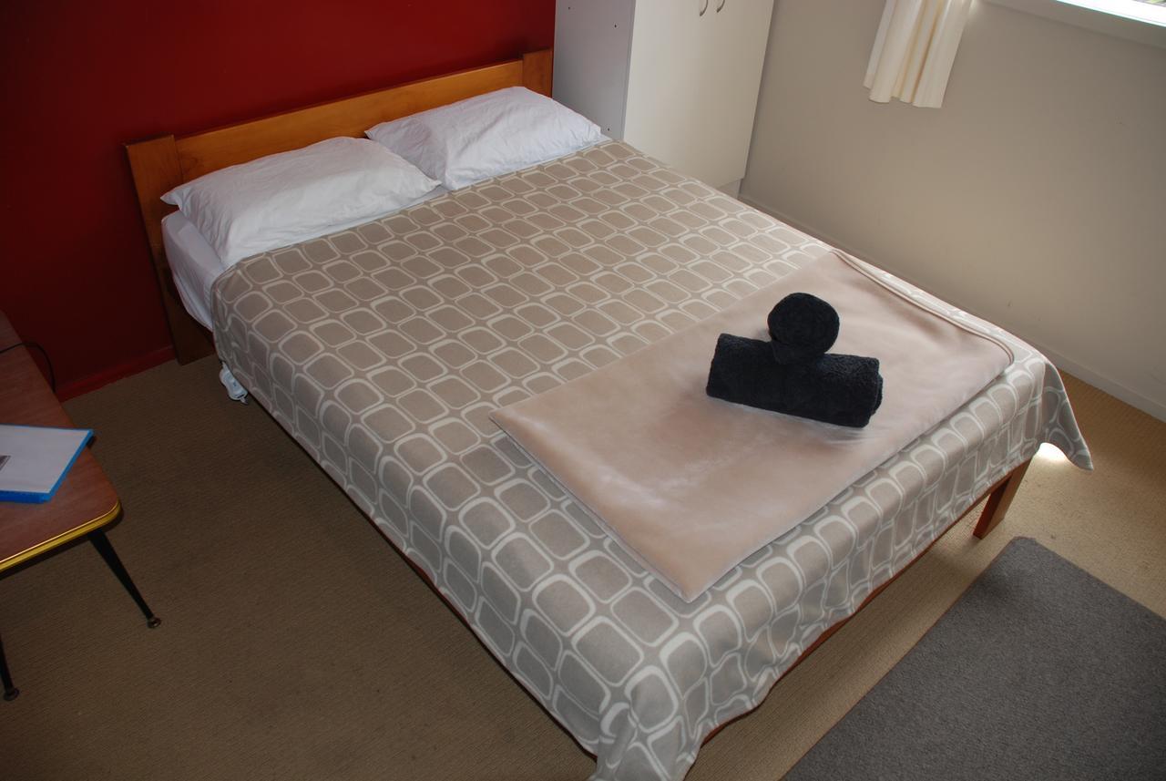 Riverstone Lodge Turangi Buitenkant foto A bed with a duvet
