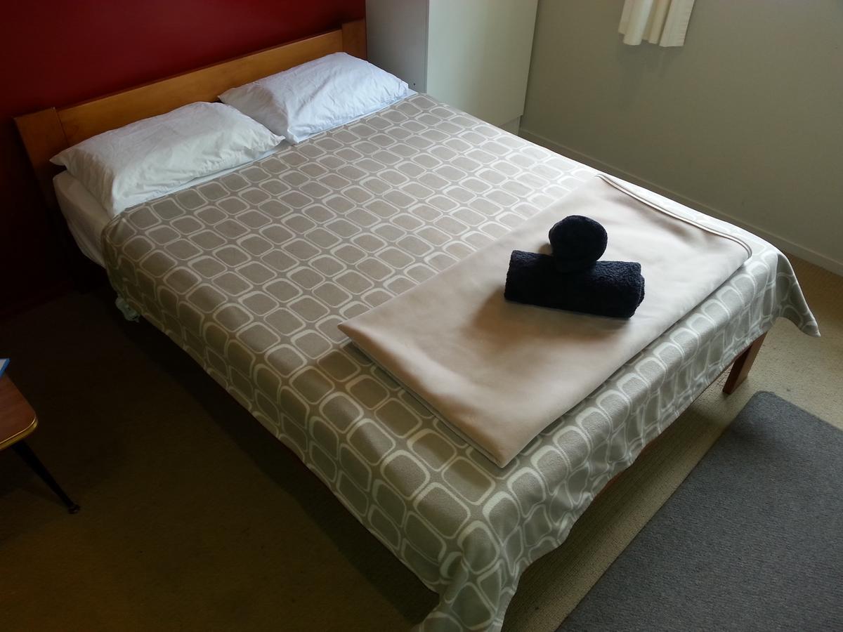 Riverstone Lodge Turangi Buitenkant foto A bed with a duvet